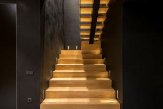 Un escalier en bois rénové valorise l'entrée lumineuse d'une maison ancienne