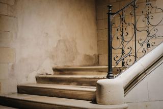 Un escalier en bois rénové valorise l'entrée lumineuse d'une maison ancienne